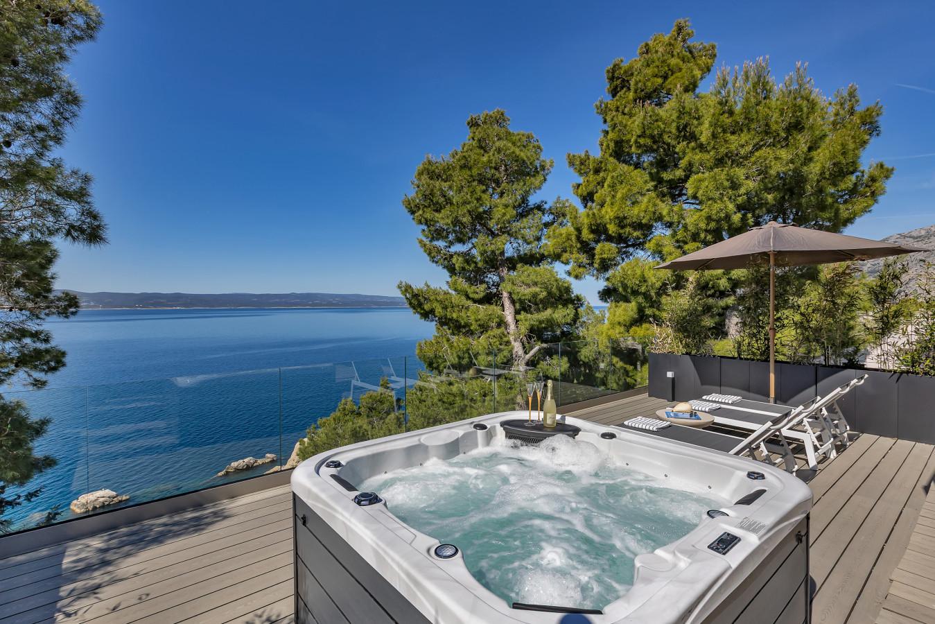 Hot tub and sun loungers on the sea-facing terrace at Beach House Tramonto in Brela
